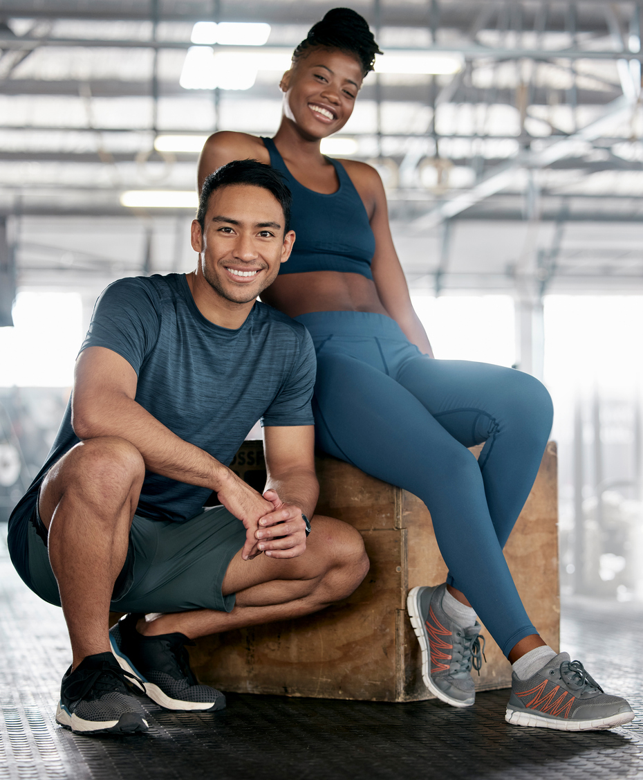 Personal trainer with a happy client at gym for training.